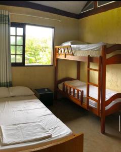 塔曼达雷Chalé Azul的一间卧室设有两张双层床和一扇窗户。