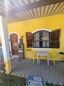 ItaririPousada_tres_amores的天井上的黄色房屋,配有桌椅