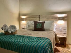 圣克里斯托瓦尔-德拉斯卡萨斯Casa Cheleb的一间卧室配有一张大床和木制床头板