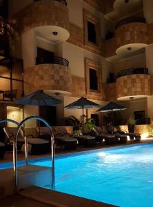 吉达EWG Golden Sea Hotel Obhur的一座带椅子和遮阳伞的游泳池
