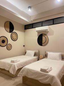 曼谷Rema residence China town的两张睡床彼此相邻,位于一个房间里
