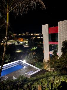 库尼亚Pitaya Suítes的一座游泳池,在晚上在建筑物前