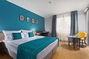 克雷费尔德Trip Inn Hotel Krefeld的一间卧室设有一张蓝色墙壁的大床