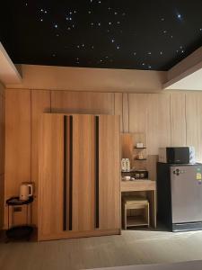 曼谷Rema residence China town的厨房配有冰箱和带微波炉的桌子。
