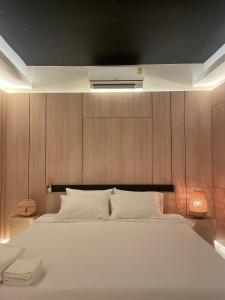 曼谷Rema residence China town的卧室配有一张白色大床和木墙