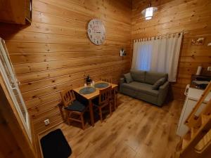 罗瓦涅米Lapland Forest Lodge的一间设有桌子、沙发和时钟的房间