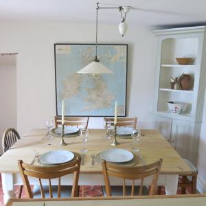 赛伦塞斯特Characterful Cotswold cottage的一张餐桌,配有四把椅子和一幅大画