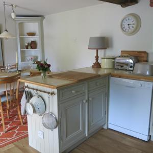赛伦塞斯特Characterful Cotswold cottage的厨房配有灰色橱柜和台面