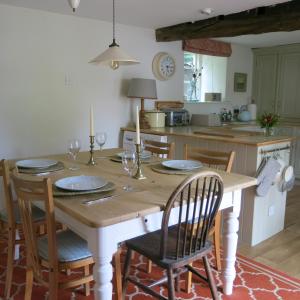 赛伦塞斯特Characterful Cotswold cottage的厨房配有木桌,上面放有盘子和玻璃杯