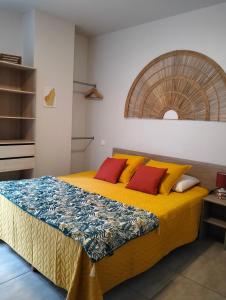 罗纳河畔的图尔农Tikazéla - Escale Tournon-Sur-Rhône的一间卧室配有黄色和红色枕头的床