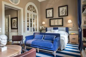 佛罗伦萨帕拉索维奇耶堤德波卡住宅酒店的一间卧室配有蓝色的沙发和一张床