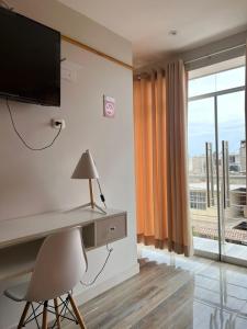 钦博特Paris Senlis Hostel Plus的客房设有书桌、电视和窗户。