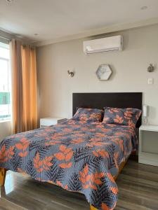 钦博特Paris Senlis Hostel Plus的一间卧室配有一张带橙色和黑色棉被的床