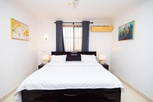 阿克拉Stay Play Away Residences - 3 bed, Airport Residential, Accra的一间卧室配有一张带白色床单的大床