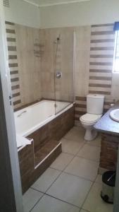 约翰内斯堡玛赞兹岩石旅馆的带浴缸、卫生间和淋浴的浴室。