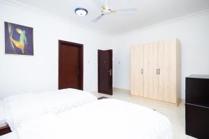 阿克拉Stay Play Away Residences - 3 bed, Airport Residential, Accra的卧室设有两张床,配有白色的墙壁和木制橱柜。