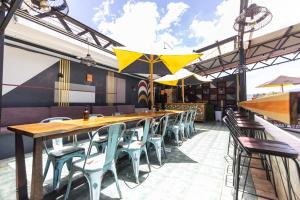 圣何塞Selina San Jose的一间带桌椅和遮阳伞的餐厅