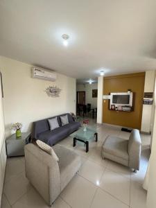 瓜亚基尔Garzota Suites Airport Balcony的客厅配有沙发、椅子和电视