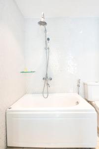 胡志明市Diamond Boutique Hotel 36的带淋浴的浴室配有白色浴缸。