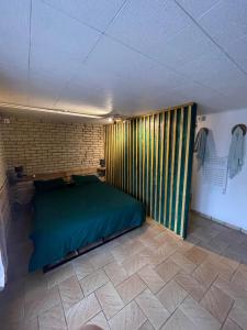 兰斯Le Ranch - chambres privées - proche centre ville的一间位于客房内的带绿床的卧室