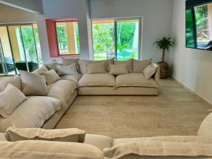阿文图拉斯港Sasay的客厅设有一张大沙发,配有窗户