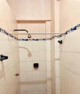 普卡尔帕Hotel Juan Diego Pucallpa的浴室设有蓝色和白色瓷砖淋浴。