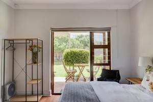 赫曼努斯Beautiful Abalone的一间卧室设有一张床,并有通往庭院的门