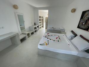 瓦塔穆Ascot Watamu的白色卧室配有带花卉装饰的床