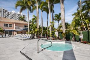 劳德代尔堡椰子湾度假公寓的棕榈树庭院内的热水浴池