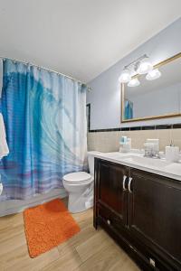 可可比奇Downtown Cottage - Walk to the Beach & Restaurants的浴室设有盥洗盆、卫生间和淋浴帘。