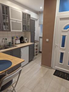 克塞洛Várfal apartman的厨房配有灰色橱柜、桌子和门