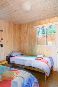 蒂尔卡拉Glamping El Obrador Tilcara的木间设有两张床,设有窗户