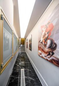 海若克利欧Royal Gold City Suites的墙上挂有绘画的走廊