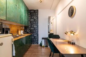 布拉迪斯拉发Double-tree apartment by A&M的厨房配有木桌和绿色橱柜。