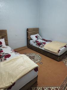 达赫拉Maison sahara的两张睡床彼此相邻,位于一个房间里