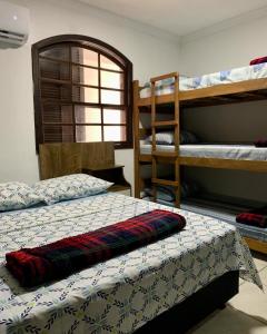 安格拉杜斯雷斯Apartamento Praia do Bonfim的一间卧室配有两张双层床和一张带毯子的床。