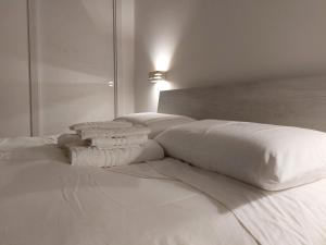 莱切l'aira ecchia - ospitalità rurale的白色的床、白色床单和枕头