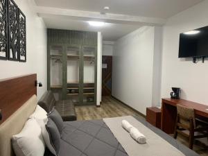 奥塔瓦洛Hotel Sacha Golden的一间卧室配有一张床、一张书桌和一台电视