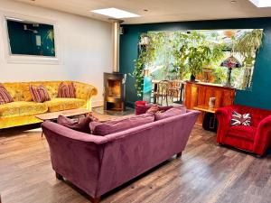 索尔科姆Brightham House的客厅配有紫色沙发和红色椅子