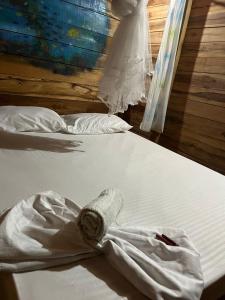 La Pozathe mompe beach hostal的两张带白色床单的床和一件连衣裙