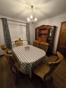 奥马Cosy 3 Bed Retreat in Omagh的用餐室配有桌椅、桌子和吊灯