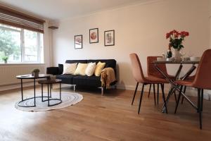 谢珀顿Perfect 2 Bedroom Flat Heathrow, Free Parking的客厅配有黑色沙发和桌子