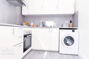 布罗姆利Inviting 3-Bed Apartment in Bromley的白色的厨房配有洗衣机
