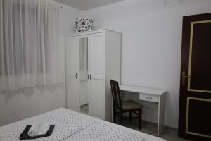 武科瓦尔Hacijenda的一间卧室配有书桌、椅子和白色橱柜