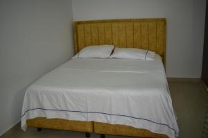 巴耶杜帕尔Casa Campo Villa Rosa的一张带木制床头板和白色床单的床