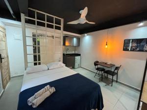 里约热内卢Ház的一间卧室配有一张带吊扇和一张桌子的床。
