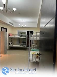 迪拜Sky Inn Hostel For Males的客房设有双层床和冰箱。