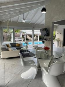 Courcelles SucrerieVilla Almeida à 500m de la plage的客厅配有玻璃桌和白色椅子