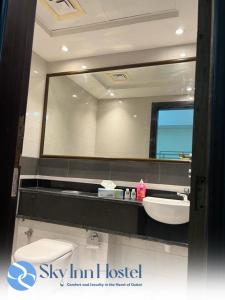 迪拜Sky Inn Hostel For Males的一间带大镜子和盥洗盆的浴室
