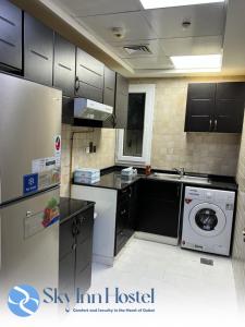 迪拜Sky Inn Hostel For Males的厨房配有洗衣机和洗衣机。